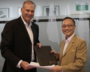 Media Monitors CEO John Croll and Brandtology CEO Eddie Chau exchange signed contracts